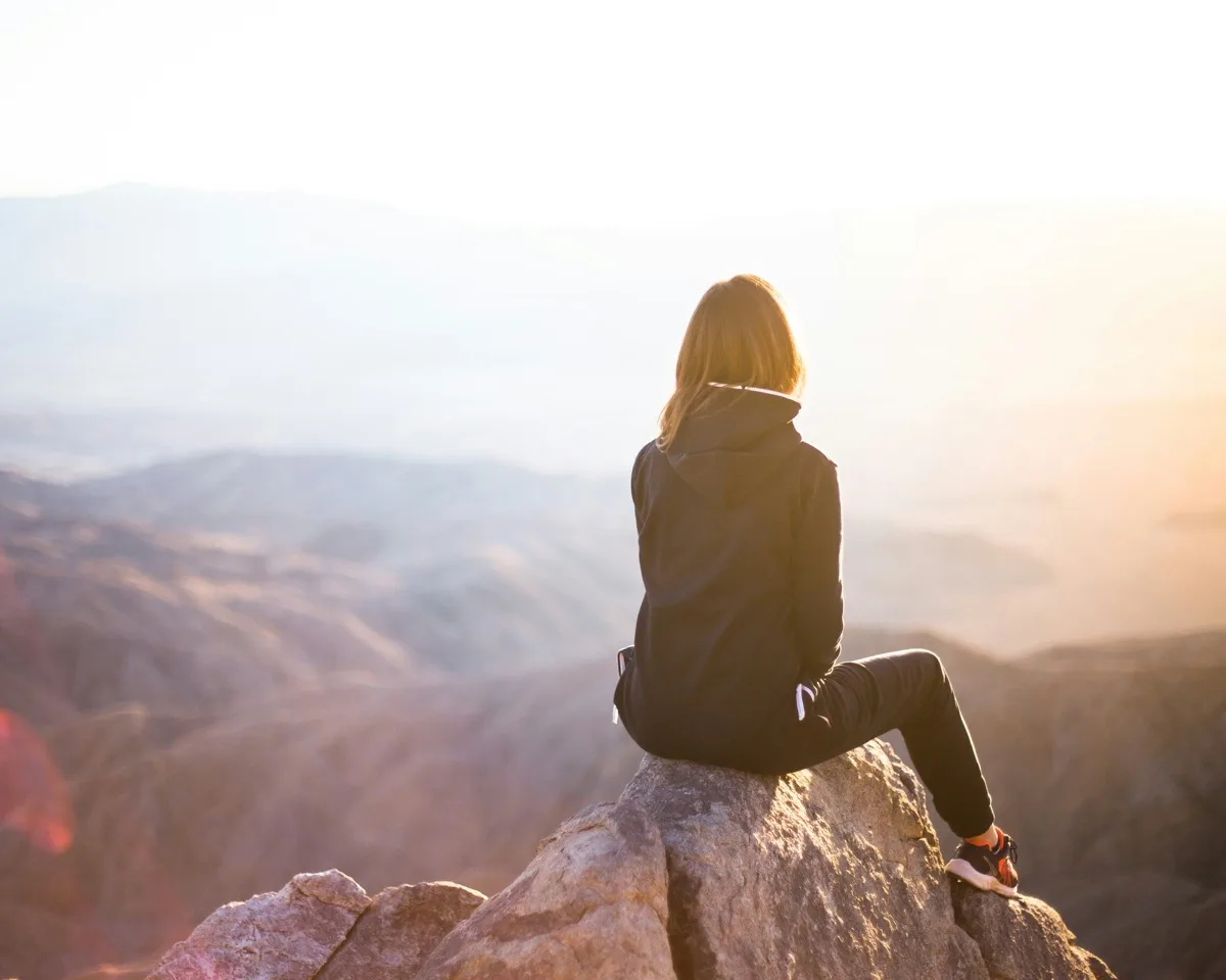Person overlooking a mountain landscape symbolizing recovery.