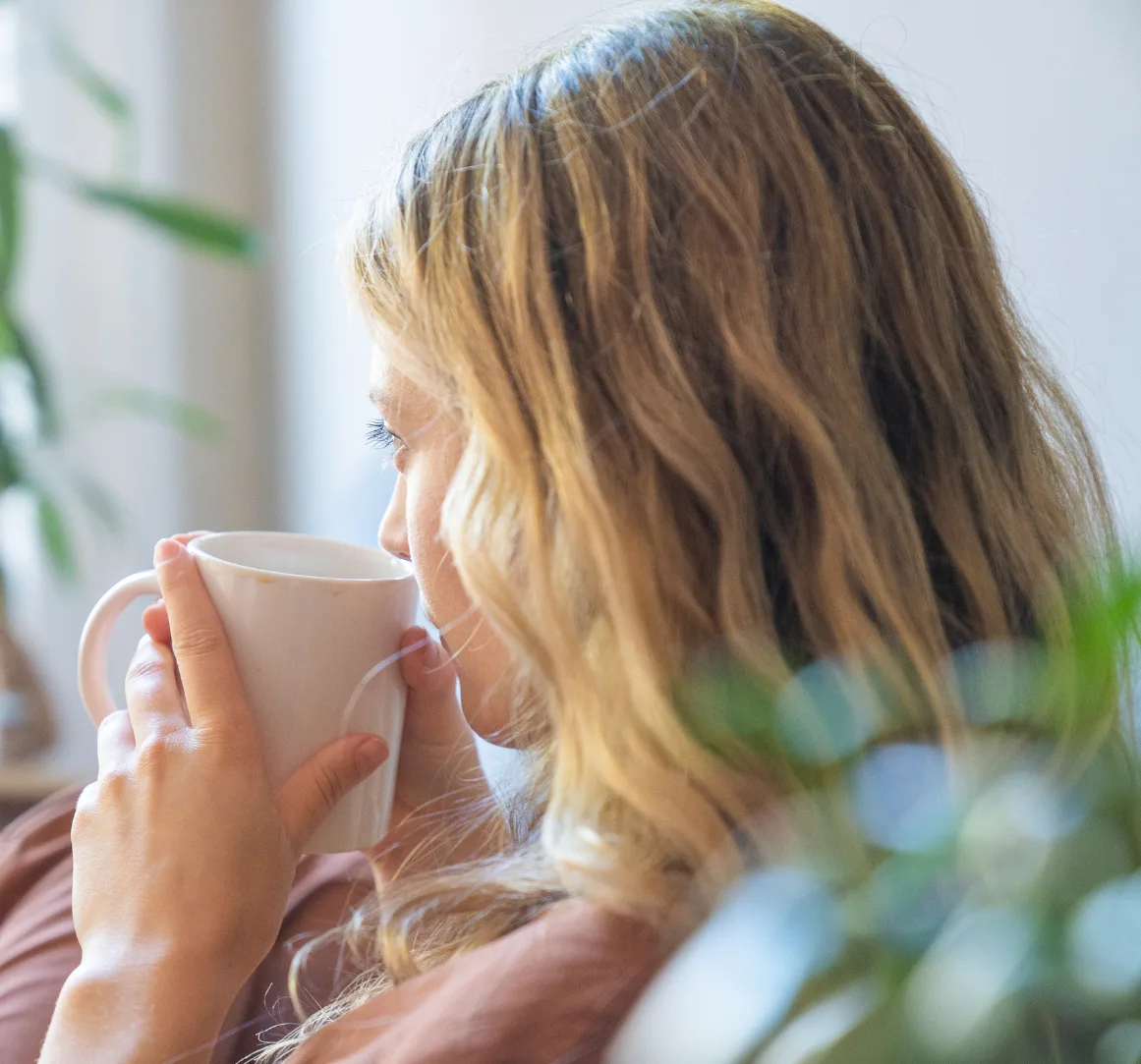 A woman relaxing with a warm cup of coffee.