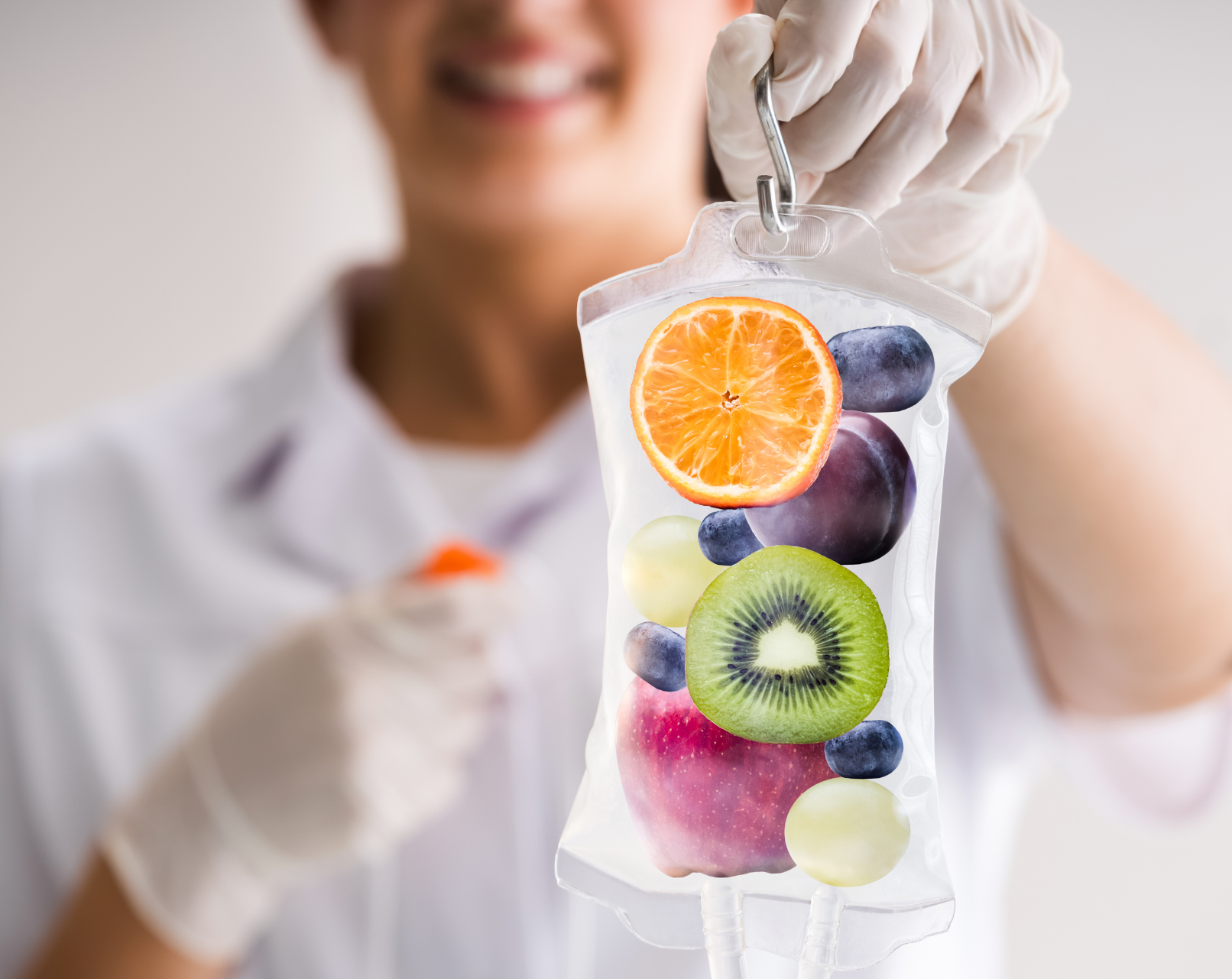 Smiling person holding a transparent IV bag filled with fresh fruits—orange, kiwi, grapes, blueberries, and more—symbolizing nutrient-rich wellness. Featured on the Mind Rejuvenation IV Vitamin Therapy page to represent vitality, holistic care, and the power of natural healing.
