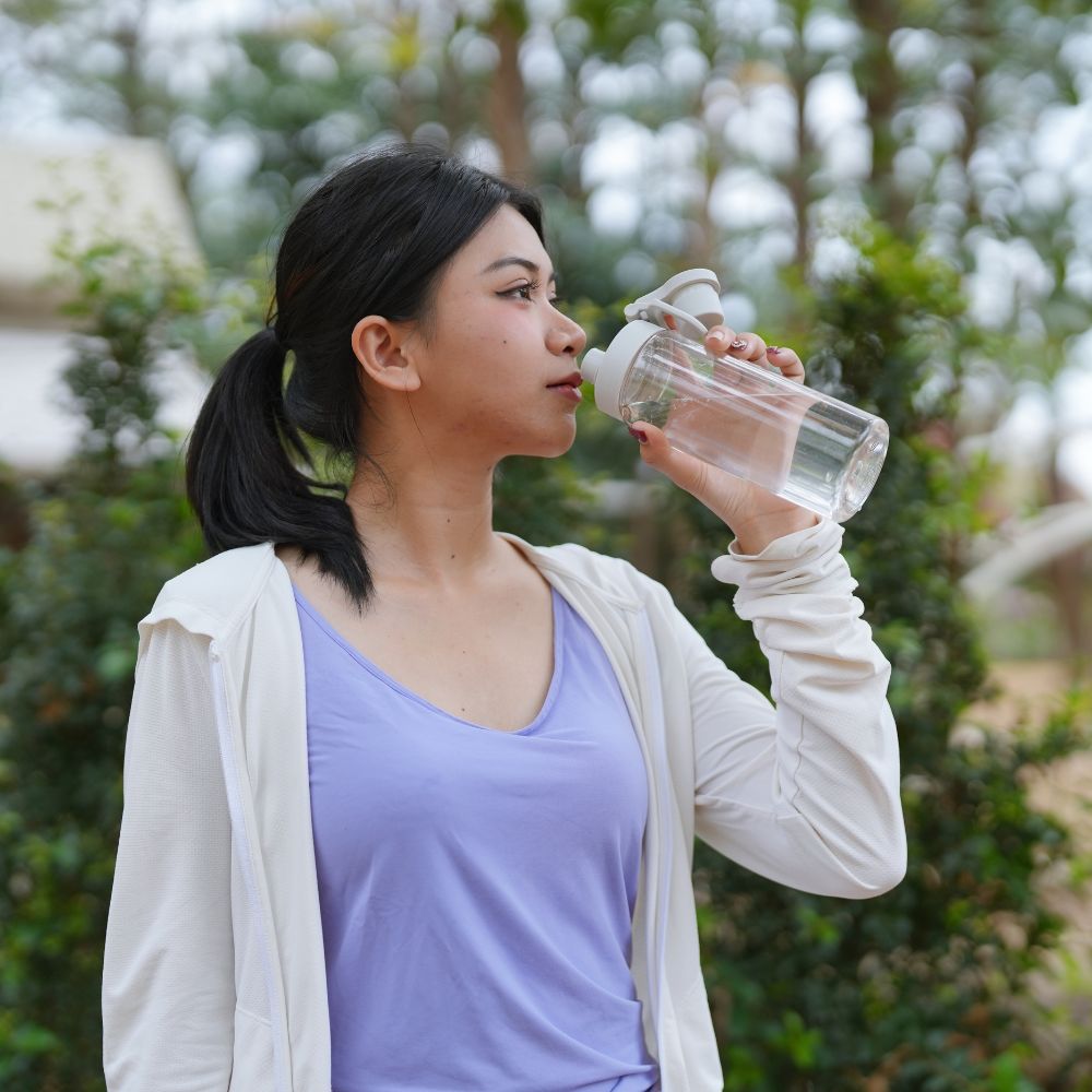 Individual drinking water outdoors, symbolizing balanced daily routines and supportive psychiatric medication management for mental health.